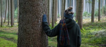 Juli mit Schal, Handschuhen und Stirnband von hinten im Wald